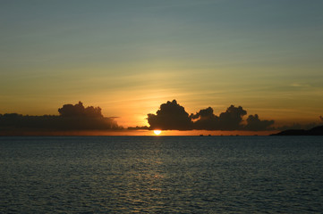 Naklejka na ściany i meble オレンジ色の夕日が水平線に落ちる穏やかな海