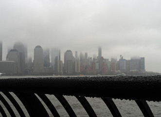 Droplets on handrail and New York city covered in fog in the background