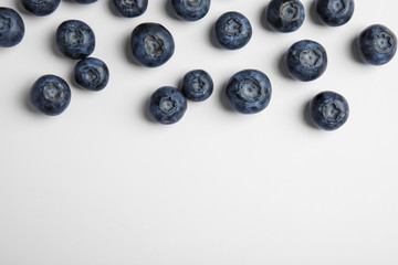 Obraz na płótnie Canvas Tasty ripe blueberries on white background, flat lay