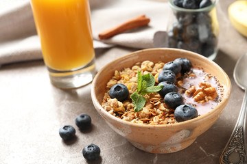 Bowl of tasty oatmeal with blueberries and yogurt on marble table
