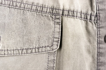 clothing items stonewashed cotton fabric texture with seams, clasps, buttons and rivets, macro