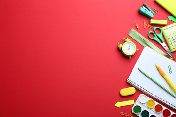 Bright school stationery on red background, flat lay. Space for text