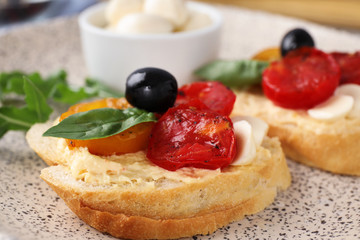 Delicious tomato bruschettas on ceramic plate, closeup