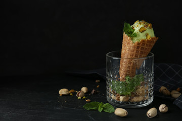 Delicious pistachio ice cream on dark table. Space for text