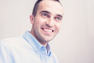 Young attractive man smiles. Portrait, close up, toned