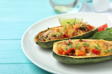 Delicious stuffed zucchini served on light blue wooden table, closeup