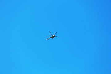 Modern military helicopter flying in blue sky
