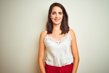 Young beautiful woman wearing t-shirt standing over white isolated background with a happy and cool smile on face. Lucky person.