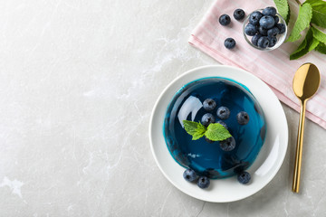 Delicious jelly with blueberries and mint on grey table, flat lay. Space for text