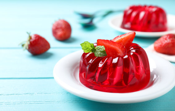 Delicious red jelly with strawberry and mint on light blue wooden table