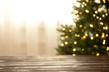 Empty table and blurred fir tree with yellow Christmas lights on background, bokeh effect. Space for design - Powered by Adobe