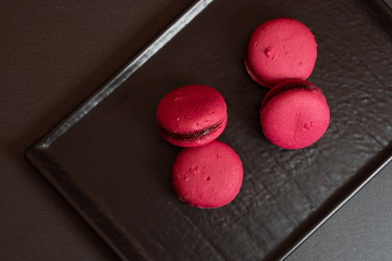 Raspberry macarons on a slate plate