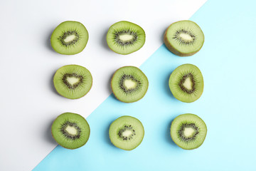 Fototapeta premium Top view of sliced fresh kiwis on color background