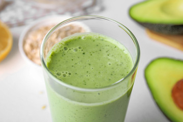 Glass of tasty avocado smoothie on table, closeup