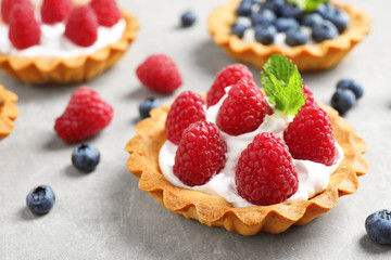 Delicious sweet pastry with berries on grey table, closeup