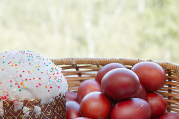 Easter spring cake with painted chicken eggs in a wicker basket