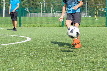Soccer player on the soccer field plays the ball. Doing sports. Children play ball in a football team.