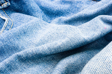 clothing items blue stonewashed faded jeans cotton fabric texture with seams, clasps, buttons and...