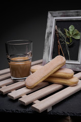 Ladyfinger biscuits for a Classic tiramisu dessert and a glass cup of coffee for dipping
