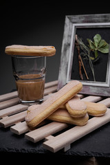 Ladyfinger biscuits for a Classic tiramisu dessert and a glass cup of coffee for dipping