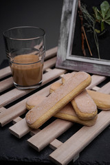 Ladyfinger biscuits for a Classic tiramisu dessert and a glass cup of coffee for dipping