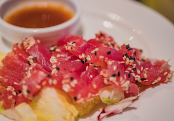 Typical Japanese dish of raw tuna on a bed of vegetables and sweet and sour sauce.