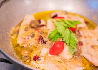 Sautéed cod with tomato, raisins, pine nuts, celery, red onion, oil, pepper and olives and olives