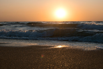 Sunset or dawn on the sea, waves and the sun.