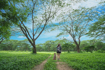 Young woman with dog are walking in a park.
