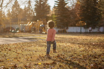Fototapeta premium Little boy running to a playground in a park