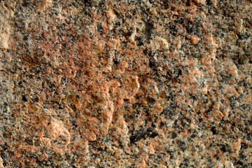 Abstract blurred natural background. Orange with black rough granite surface. Design and construction concept.
