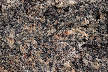 Abstract blurred natural background. Black with pink-orange rough surface of granite. Design and construction concept.