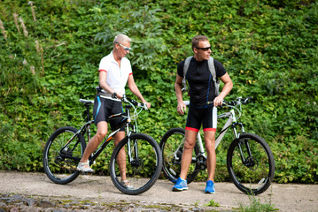 Obraz premium Sports man and woman on bikes in the park.