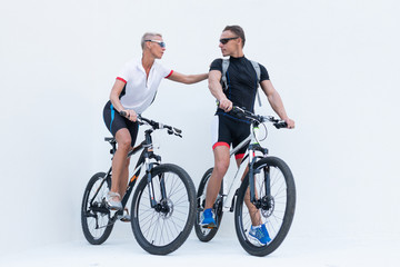 Obraz premium Man and woman with bicycles, a woman holds a man by the shoulder, on a light background.