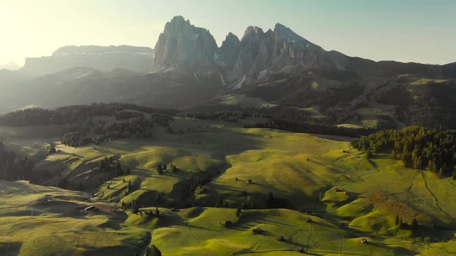 Aerial bird flying in front of drone high over Alpe di Suisi meadow in the Dolomites mountains Italy Alps. Sunrise at idyllic Seiser Alm valley, wanderlust hiking travel in Europe South Tirol