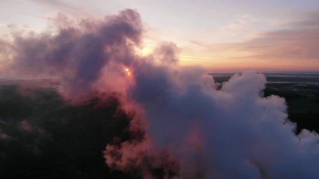 Flight above steam clouds at sunrise drone shot