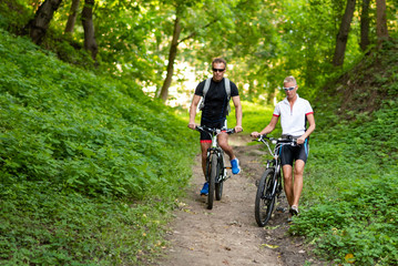 Naklejka premium A man and a woman on bicycles go down the hill.