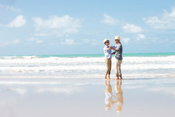 Happy asian senior couple  have fun and enjoy at the beach, senior man and woman dancing on the beach , Retirement Lifestyle Healthy  Travel Vacation Concept