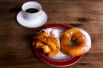 Sweet donut and cup of tea on a wooden table