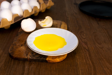 Egg yolk and egg shell on wooden table