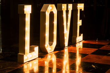insign with beautiful letters with lights of the word love - wedding and foreve concept -  nightlife dancing room background