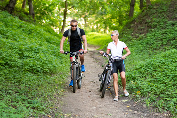 Naklejka premium A man and a woman on bicycles go down the hill.