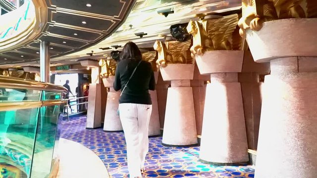 Female walking along luxurious cruise ship balcony level on carnival cruise.
