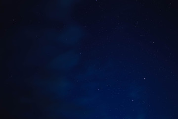 blue starry sky through gray clouds