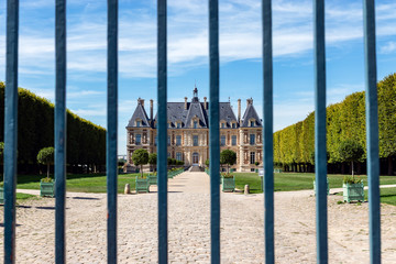 Fototapeta na wymiar View of the Chateau de Sceaux through the entrance gate - Hauts-de-Seine, France.