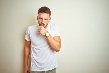 Young handsome man wearing casual white t-shirt over isolated background feeling unwell and coughing as symptom for cold or bronchitis. Healthcare concept. - obrazy, fototapety, plakaty