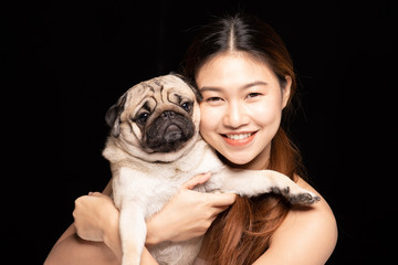 Asian woman hugging dog pud breed with love happiness emotional isolated on black background