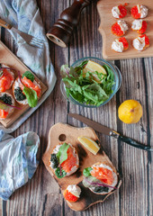 sandwiches with red, black caviar and trout .submitted on wooden planks