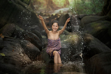 Beautiful asian woman take a bath in river in rural scene