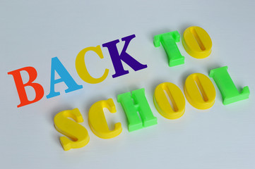 The inscription back to school plastic letters on white background. The inscription of colourfull text back to school plastic letters